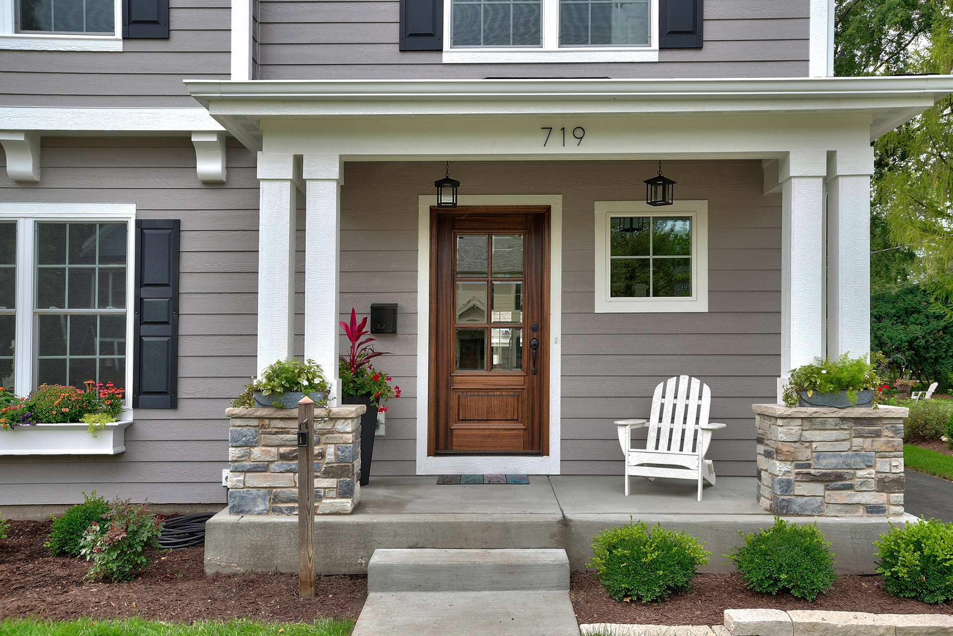 Gray siding on beautiful home with windowboxes